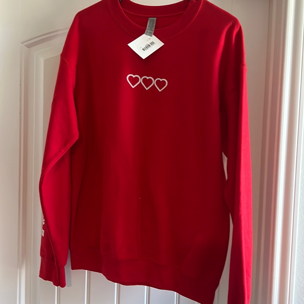 Brand new with tag. Red pullover. “Love never fails”